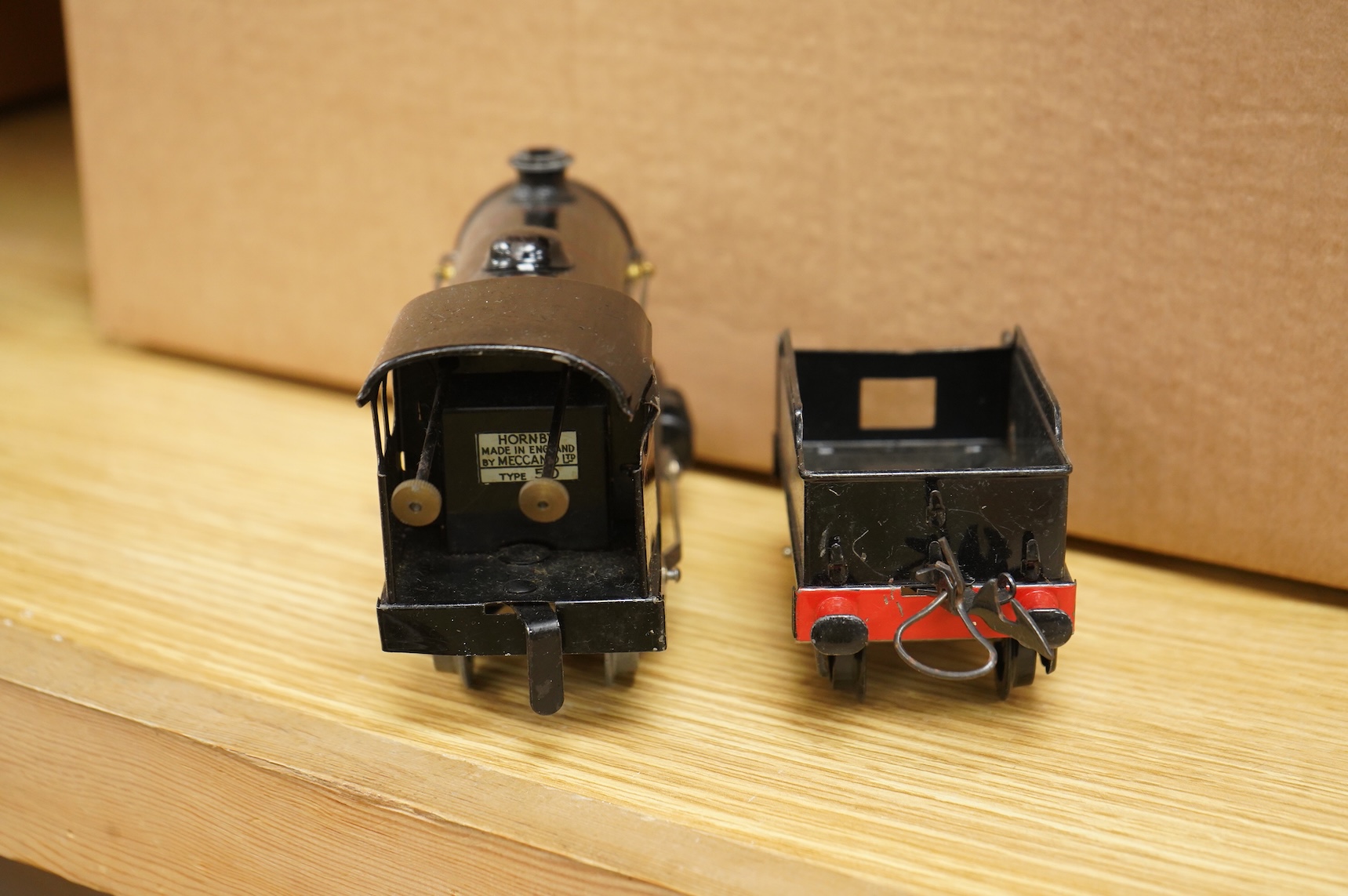 A collection of 0 gauge Hornby tinplate clockwork railway, including four BR locomotives, 17 freight wagons and four wheel coaches, together with a station building, signal cabin, and Goods depot (missing base), plus a f